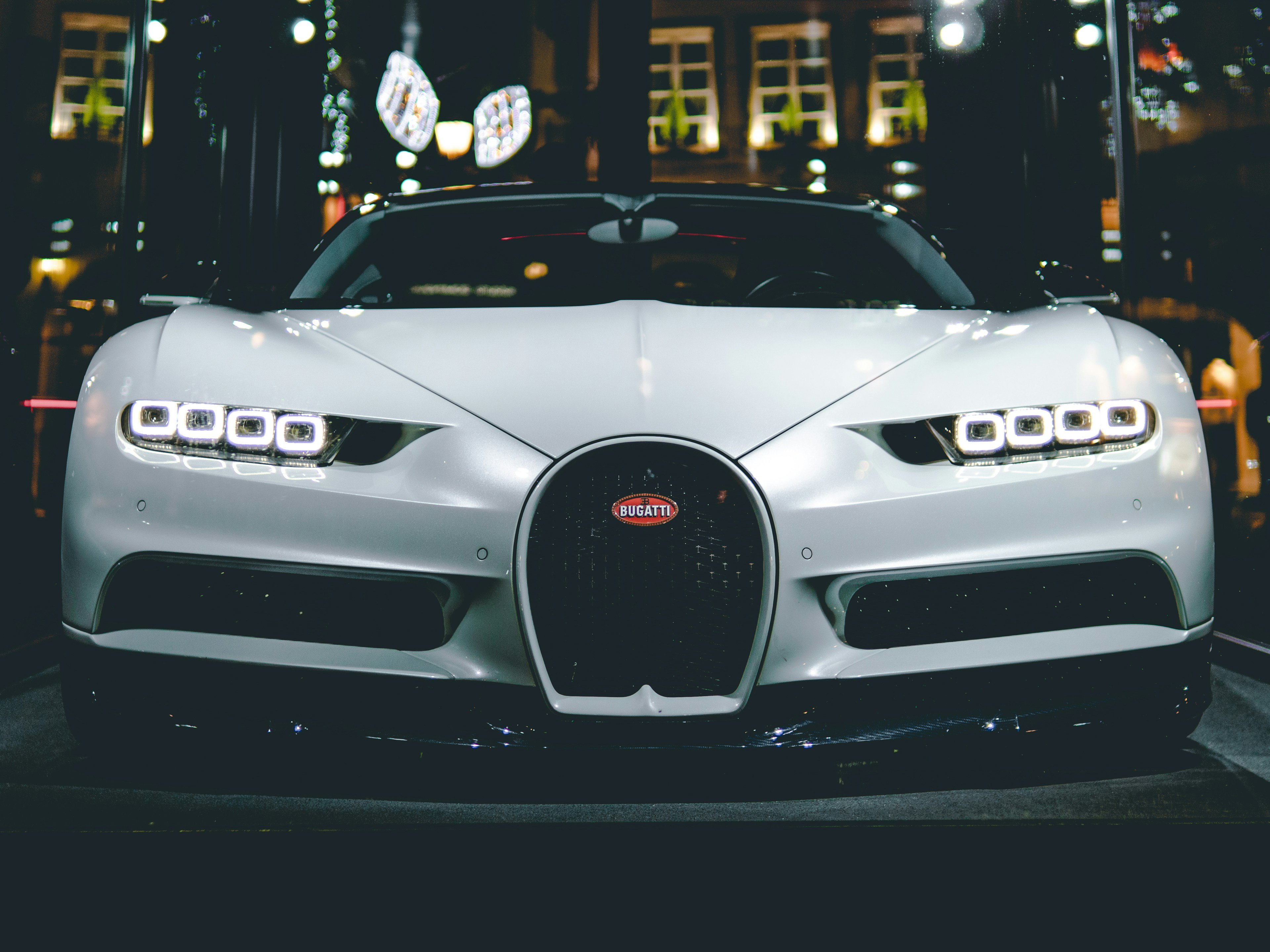 Modified sports car at a St. Louis night meet with city lights reflecting off the hood
