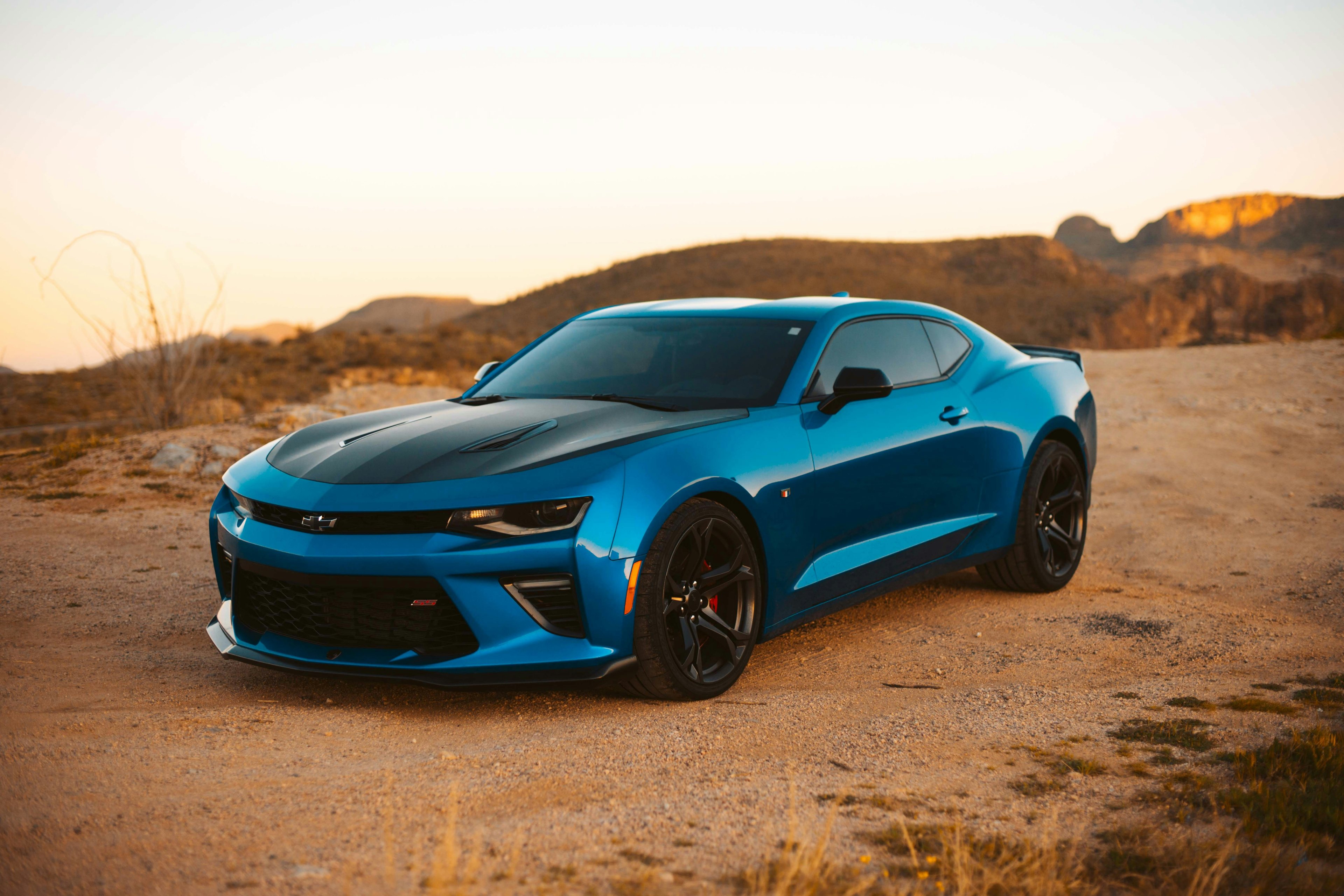 Red sports car parked at a car meet with enthusiasts gathering around it