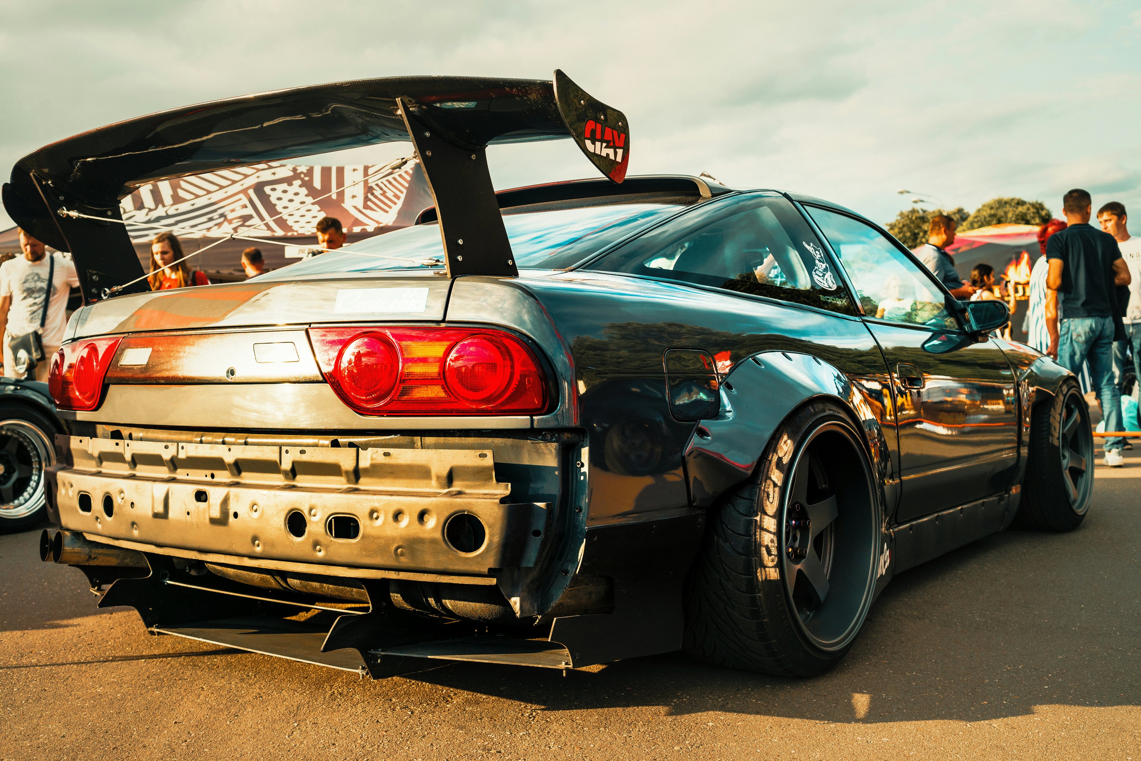 White sports car with aftermarket wheels at a Midwest car club event