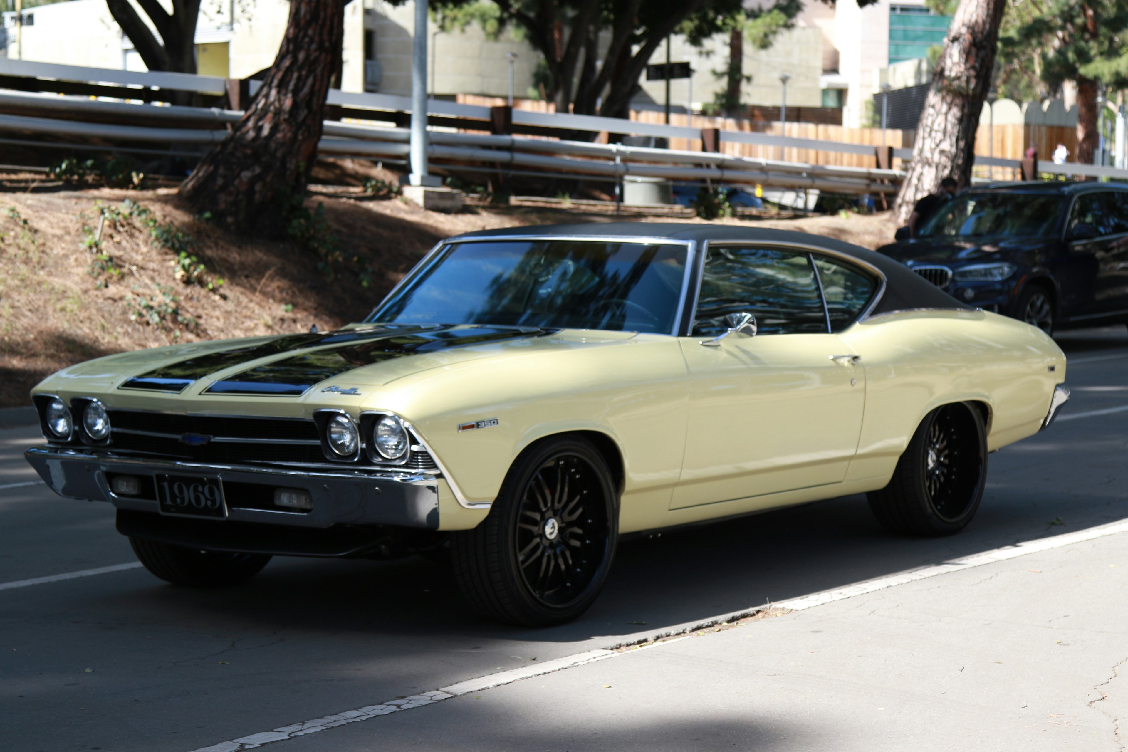 Classic 1969 Chevrolet Camaro SS with glossy black paint and chrome wheels on a sunny day